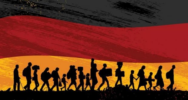 رتل من المهاجرين يسيرون أمام العلم الألماني نحو الاندماج الحقيقي