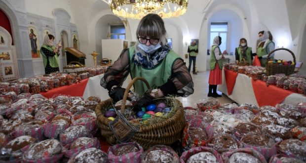 كورونا وعيد الفصح: امرأة تتفحص البيض والخبز قبل توزيعه على المحتاجين، عشية فصح الأرثوذكس